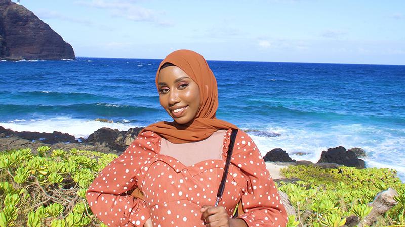 Student smiling on rocky beach